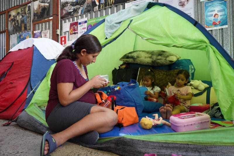 Nacer en el agua 1 Daniela y sus dos hijas se encuentran en su tienda de campaña en el albergue Movimiento Juventud 2000, en Tijuana, días antes de su parto, en julio de 2023. Foto: Alicia Fernández.