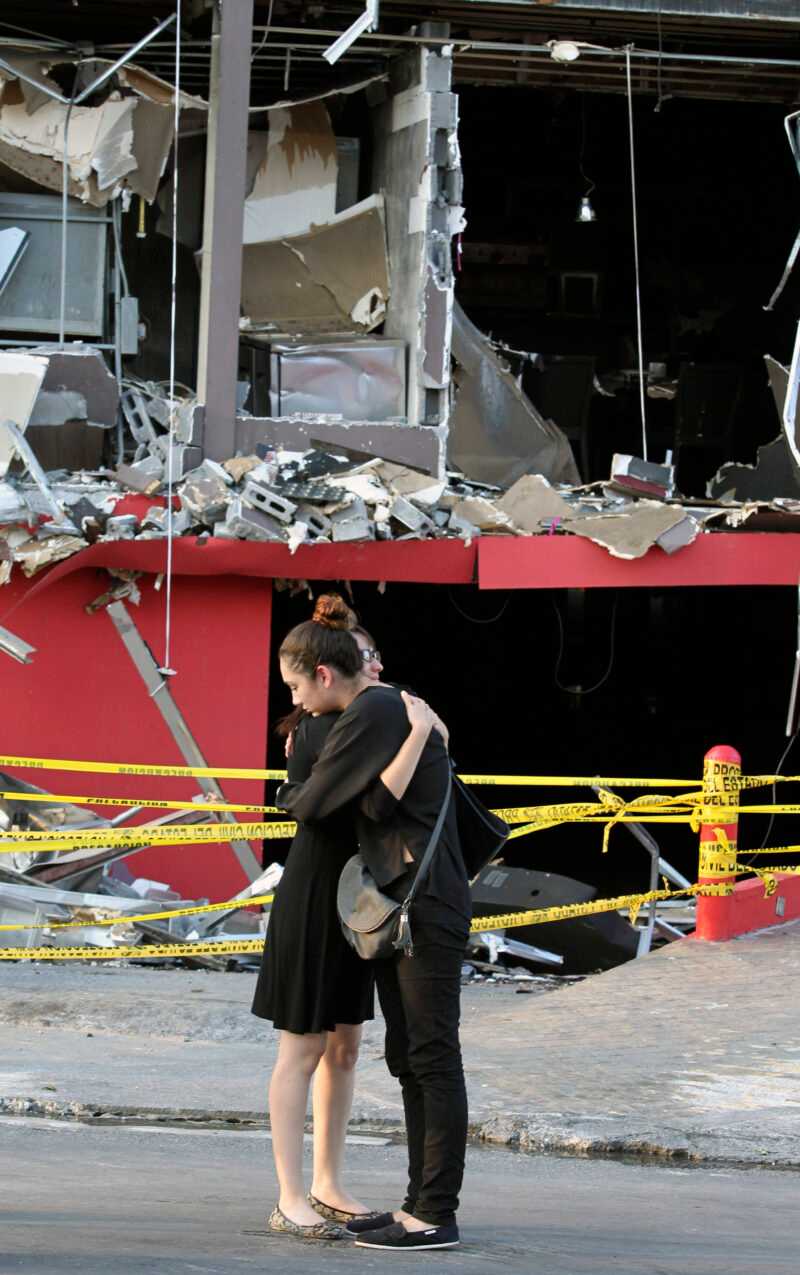 Familiares de una víctima del mortal incendio provocado en el Casino Royale se abrazan frente al establecimiento de juego calcinado en Monterrey, México, el sábado 27 de agosto de 2011. Una grabación de seguridad mostró a ocho o nueve hombres llegando al casino en cuatro vehículos el jueves y prendiendo fuego al edificio, lo que atrapó a decenas de personas en su interior y causó la muerte de al menos 52 personas, en su mayoría mujeres. (Foto AP/Hans-Maximo Musielik)